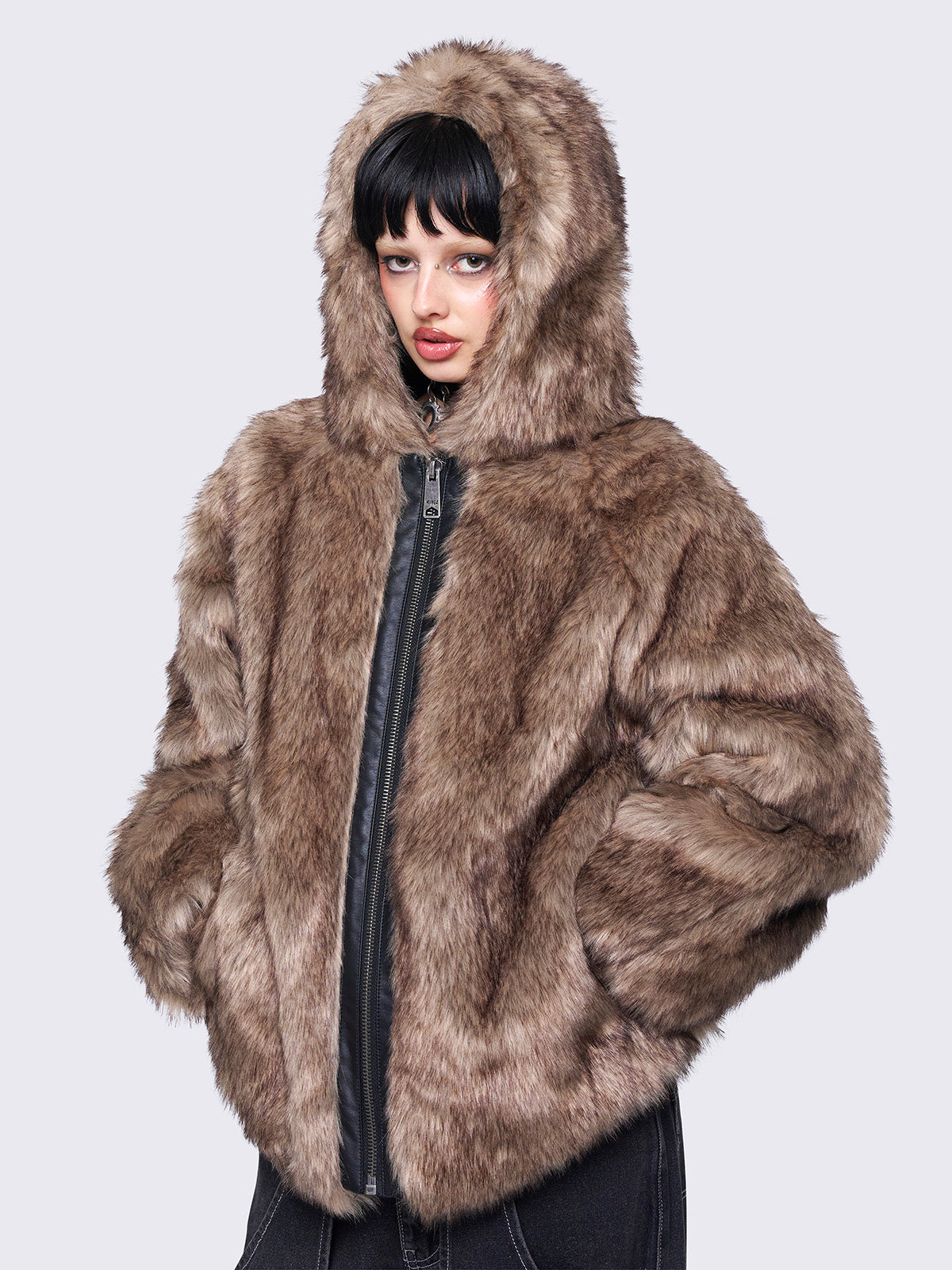 Brown faux fur hooded jacket with zip fastening and side pockets. Features a loose fit for a cozy, stylish look.