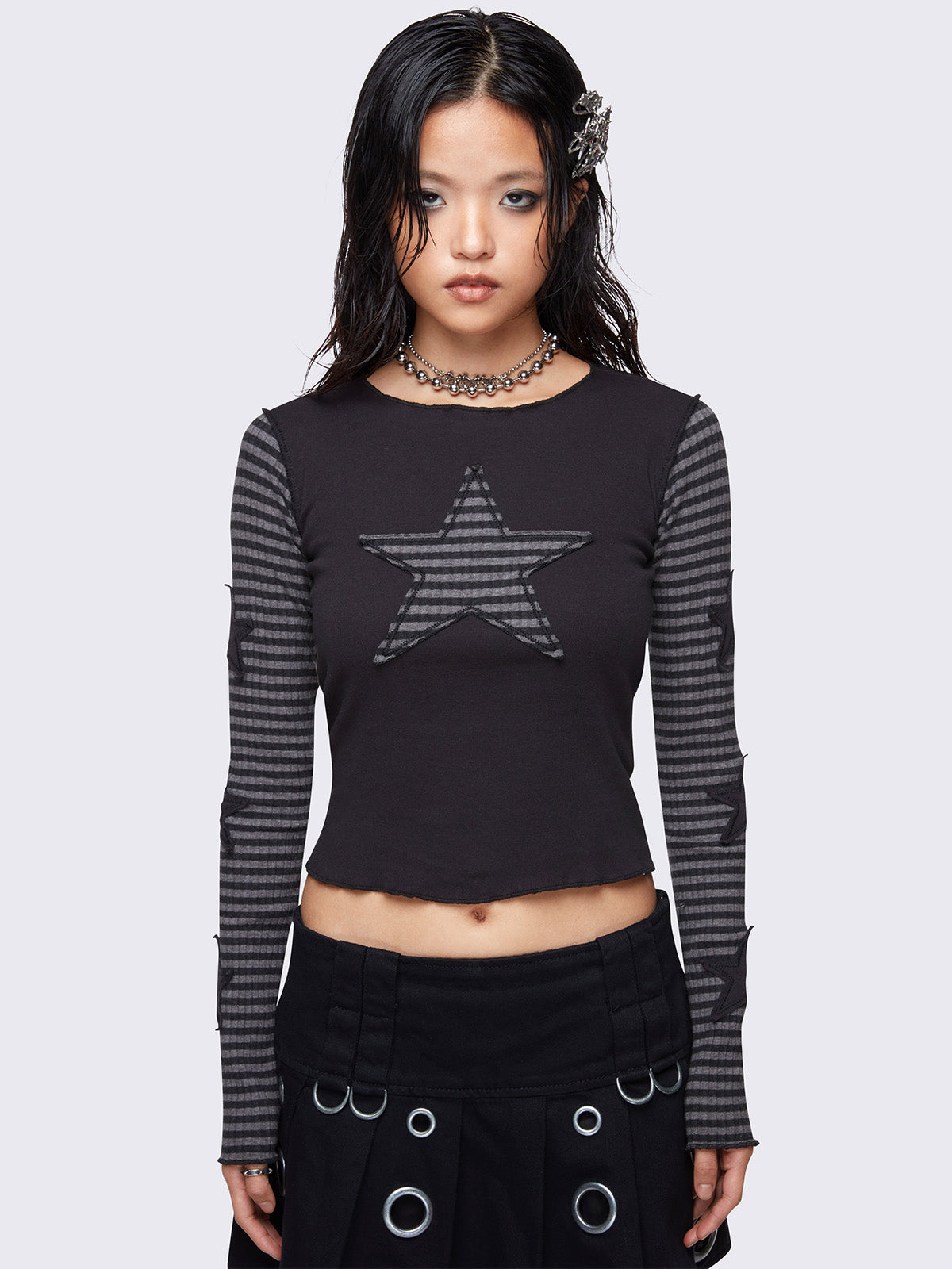 Black long-sleeve top with grey striped sleeves, a striped star patch on the front, and black stars on the sleeves. Features lettuce edge trims, reverse stitching, and a rounded neckline in a slim fit.