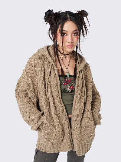 Oversized beige cable knit hooded cardigan with zip fastening and side pockets.