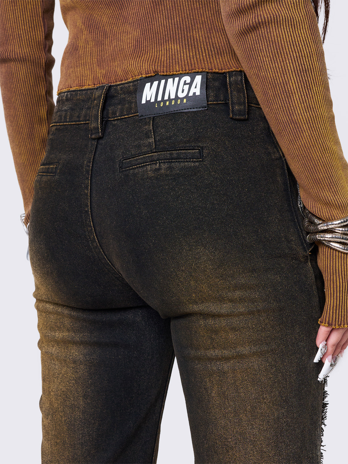 Black flared jeans featuring a honey overdye wash, a chunky buckle belt, distressed seams details and raw frayed hems. 