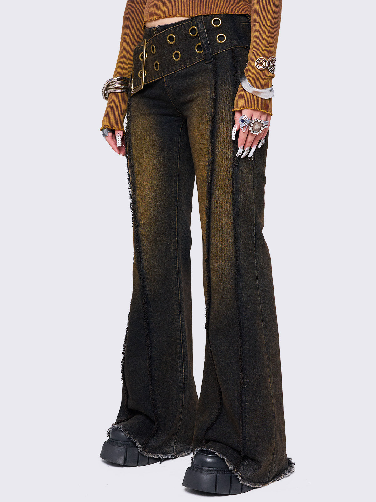 Black flared jeans featuring a honey overdye wash, a chunky buckle belt, distressed seams details and raw frayed hems. 