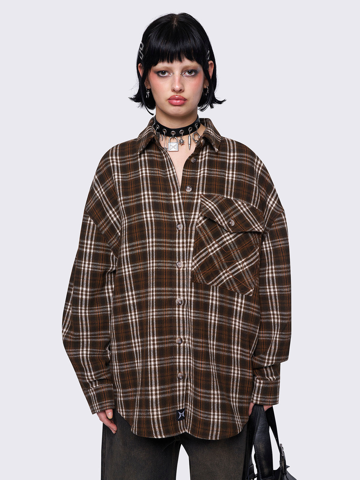 Plaid shirt in brown tones with a front button placket, chest pocket, and spread collar. Designed with long sleeves and a loose fit 