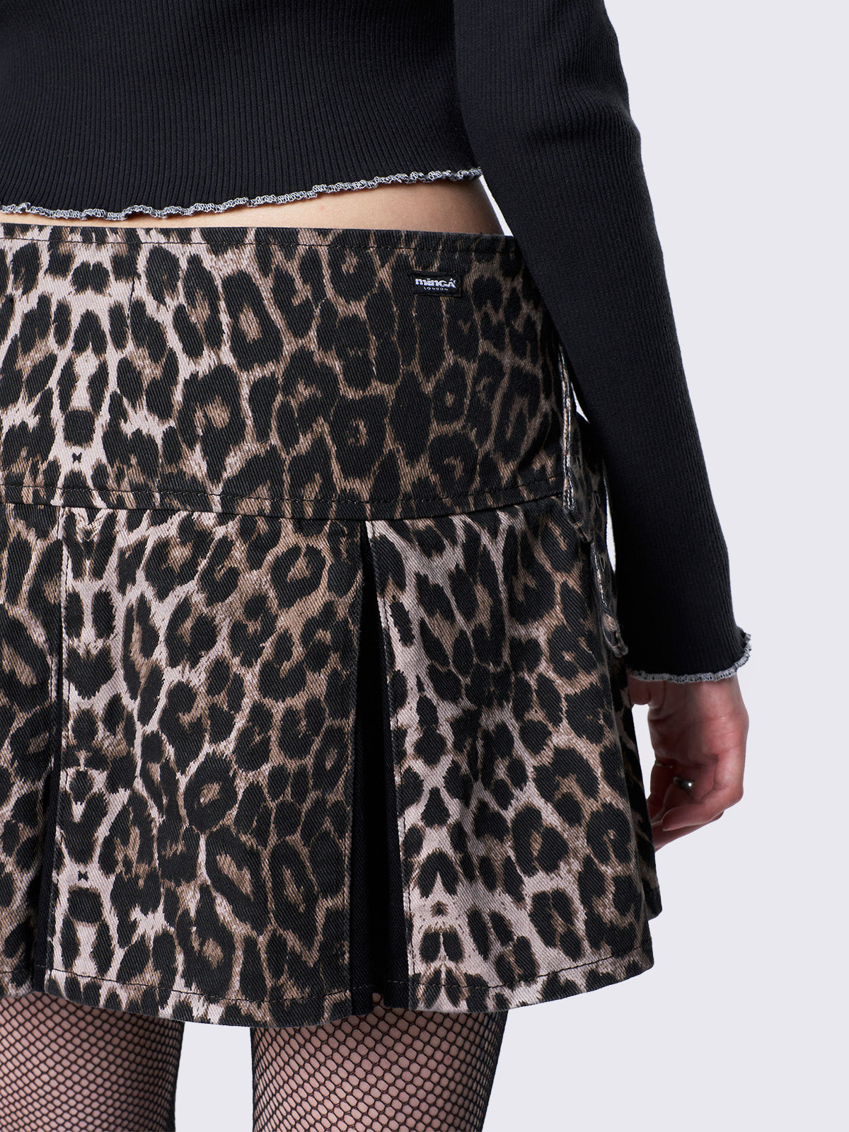 Regular waist pleated mini skirt in leopard print and contrast pleats in black. With buckle straps and D-rings details.