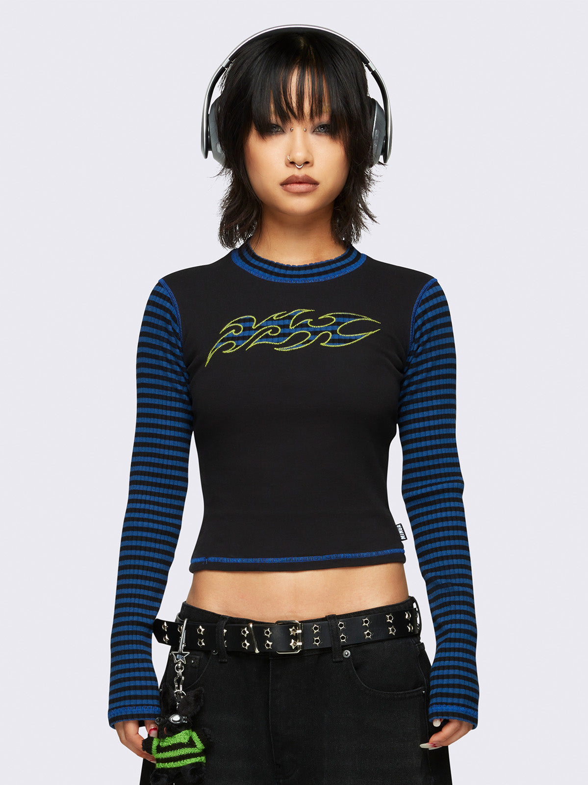 Black long sleeve top with blue and black ribbed contrast sleeves and front striped tribal patch