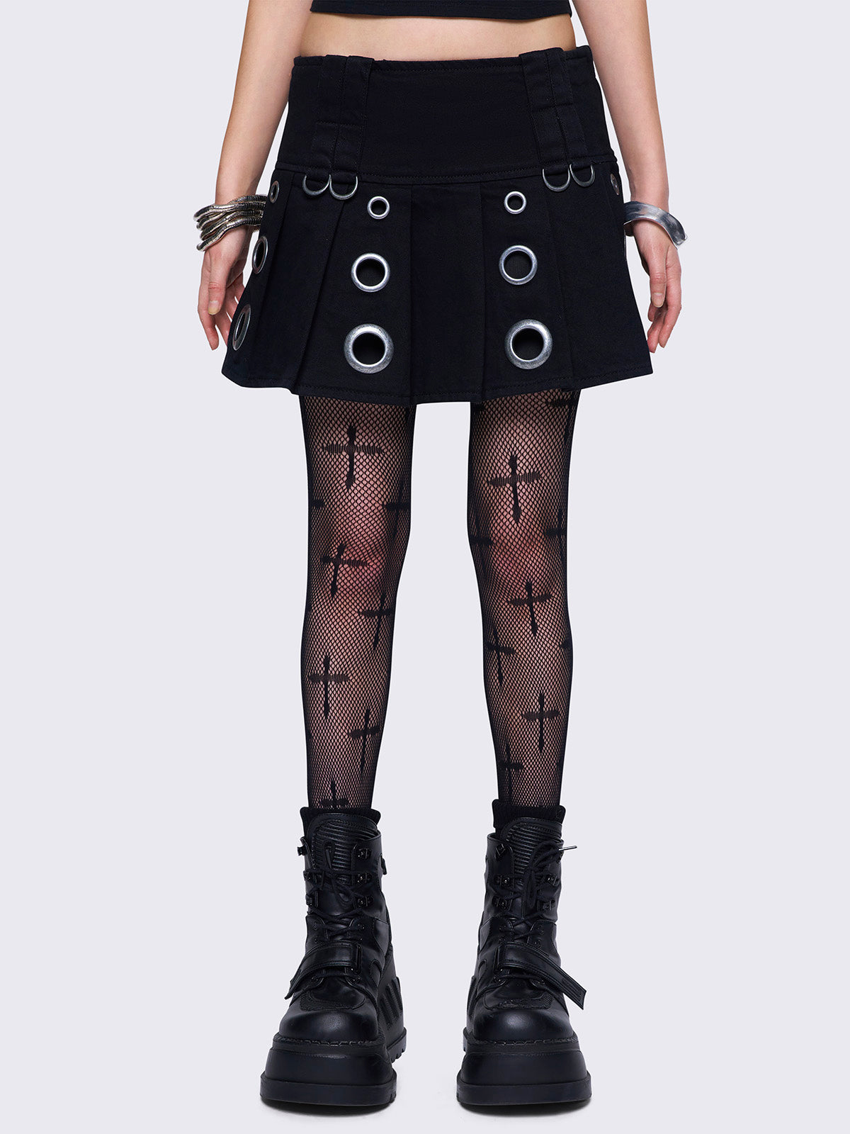 Black twill pleated mini skirt with silver eyelet details and a low waist.