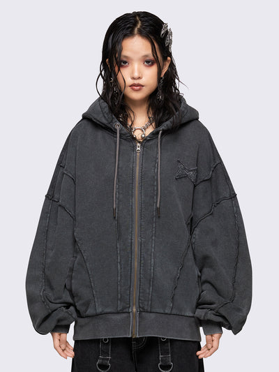 Washed grey oversized zip-up hoodie with exposed seam detailing, embroidered star patch on the chest, drawstring hood and ribbed cuffs and hem.