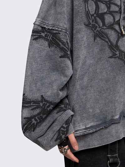 Grey distressed wash zip-up hoodie with a black barbed wire and spiderweb graphic, oversized fit, and dropped shoulders for a bold grunge aesthetic.