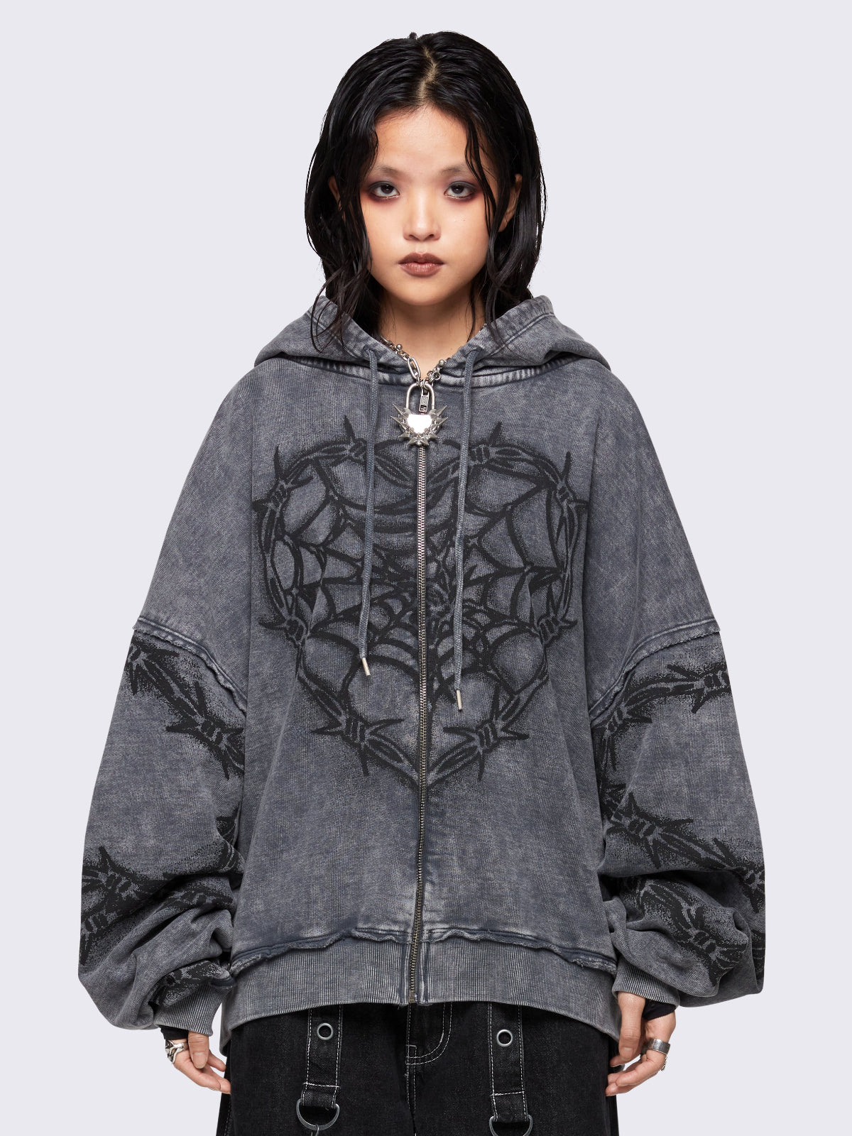 Grey distressed wash zip-up hoodie with a black barbed wire and spiderweb graphic, oversized fit, and dropped shoulders for a bold grunge aesthetic.