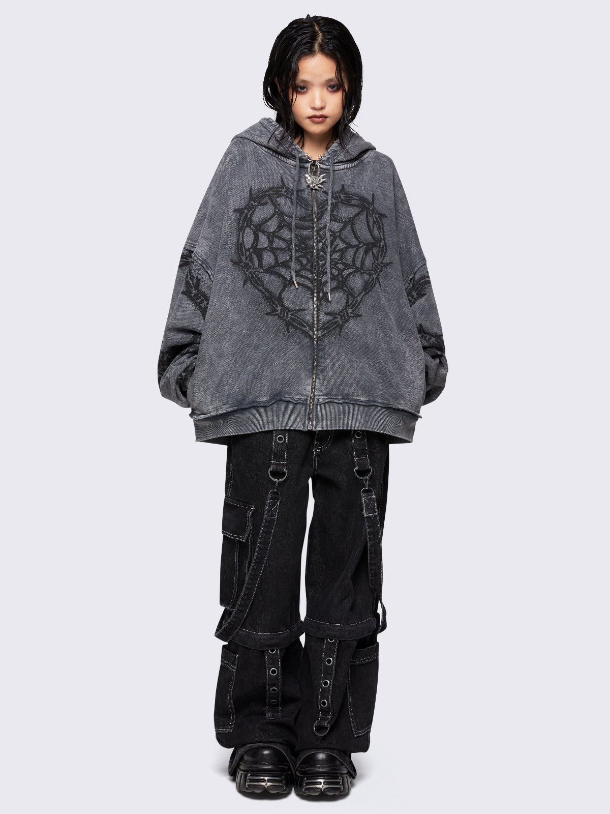 Grey distressed wash zip-up hoodie with a black barbed wire and spiderweb graphic, oversized fit, and dropped shoulders for a bold grunge aesthetic.