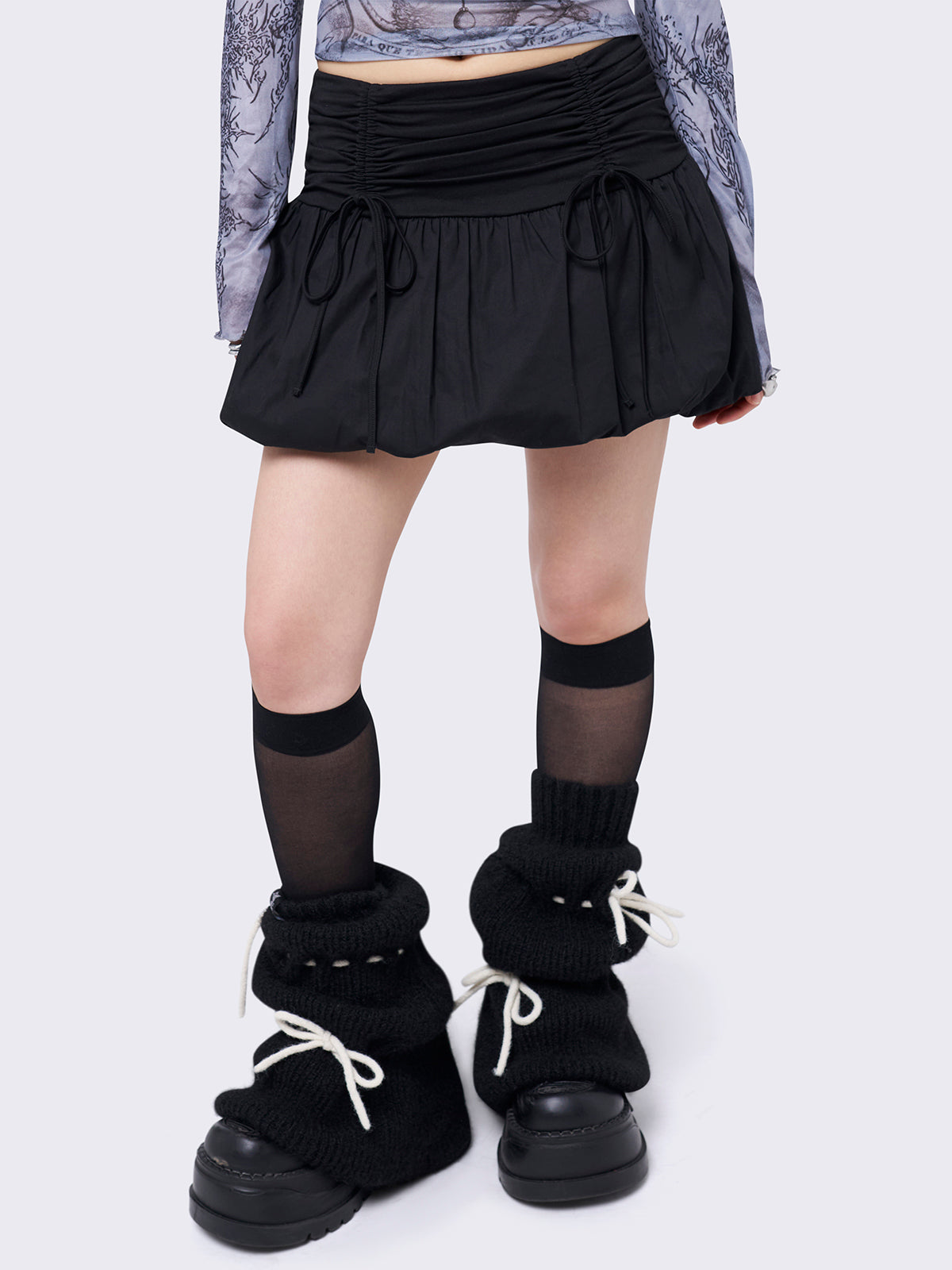 Black puffball mini skirt with a ruched tie-front and bow detail, featuring a voluminous balloon-style silhouette.