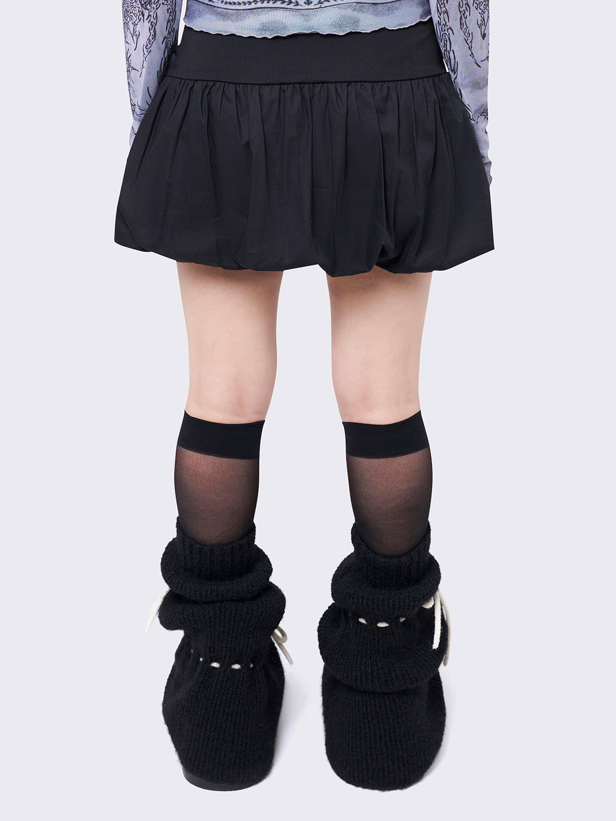 Black puffball mini skirt with a ruched tie-front and bow detail, featuring a voluminous balloon-style silhouette.