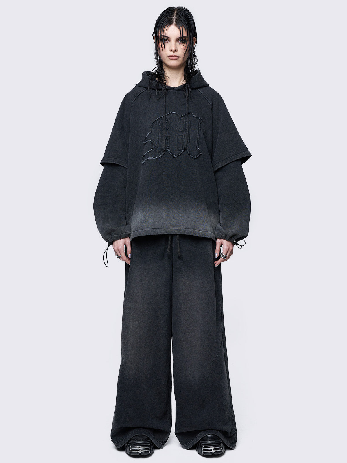 Oversized layered hoodie in washed black, featuring an embroidered 