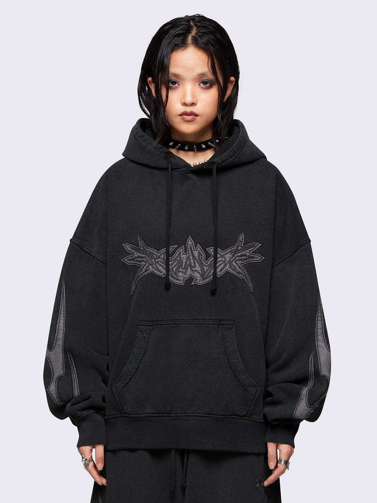 Black washed hoodie with grey sigilism embroidered patches, drawstring hood, and kangaroo pockets.