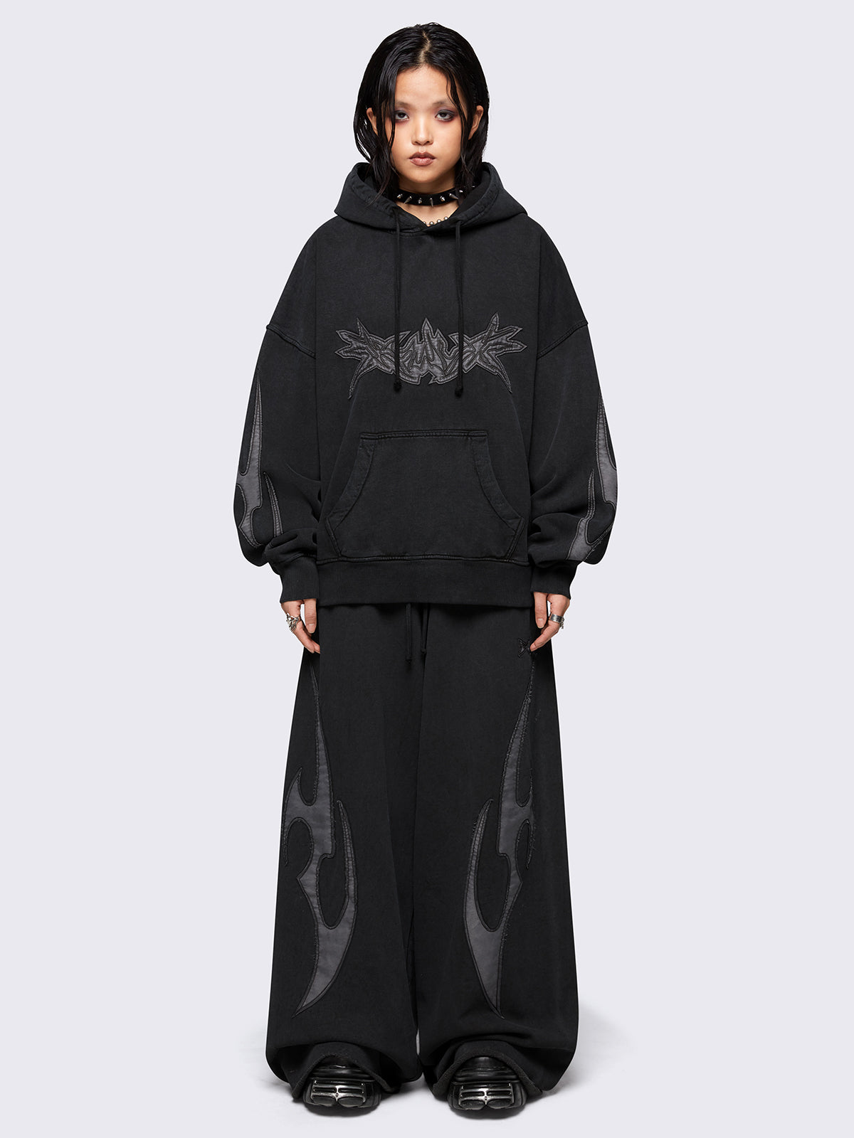 Black washed hoodie with grey sigilism embroidered patches, drawstring hood, and kangaroo pockets.