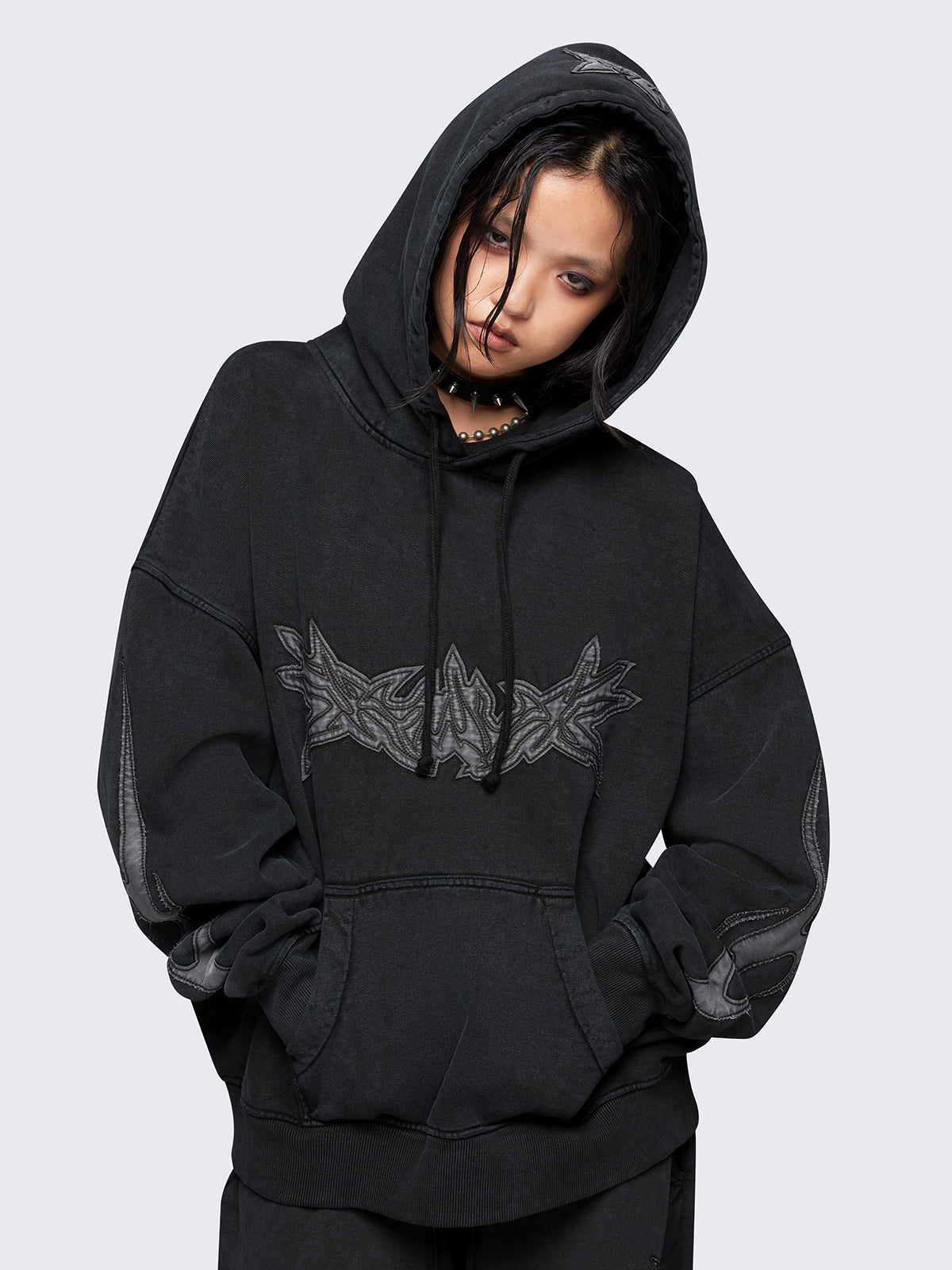 Black washed hoodie with grey sigilism embroidered patches, drawstring hood, and kangaroo pockets.