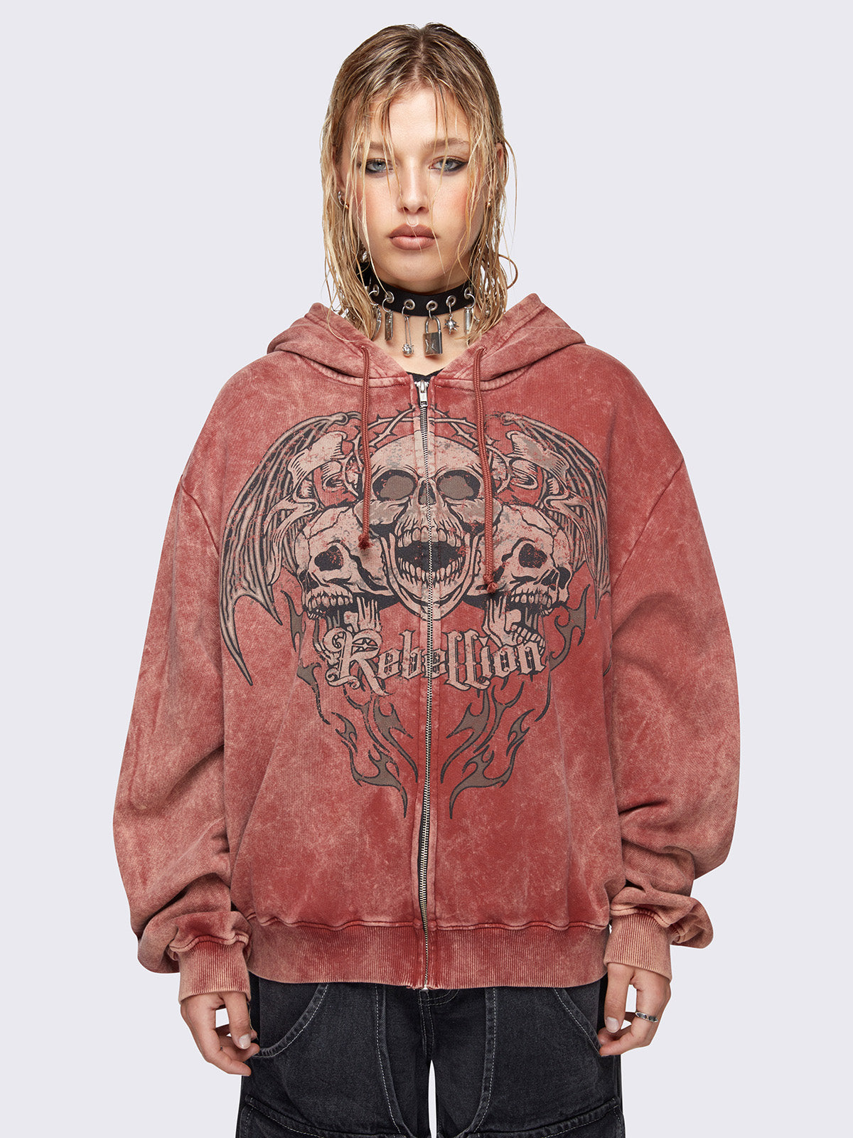 Zip up hoodie jacket in washed terracota red with rebellion skull graphic front print and drawstring hood.

