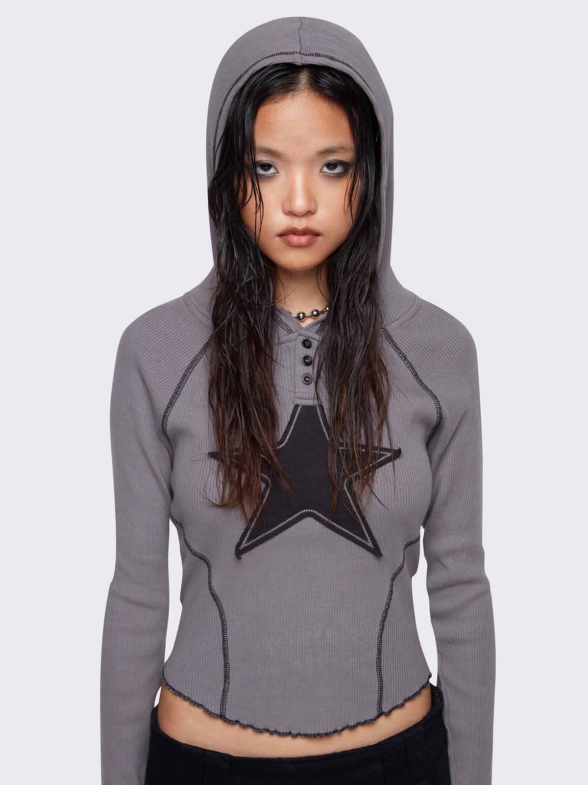 Hooded top in grey, with front star patch in black, contrast stitching in black and half button placket