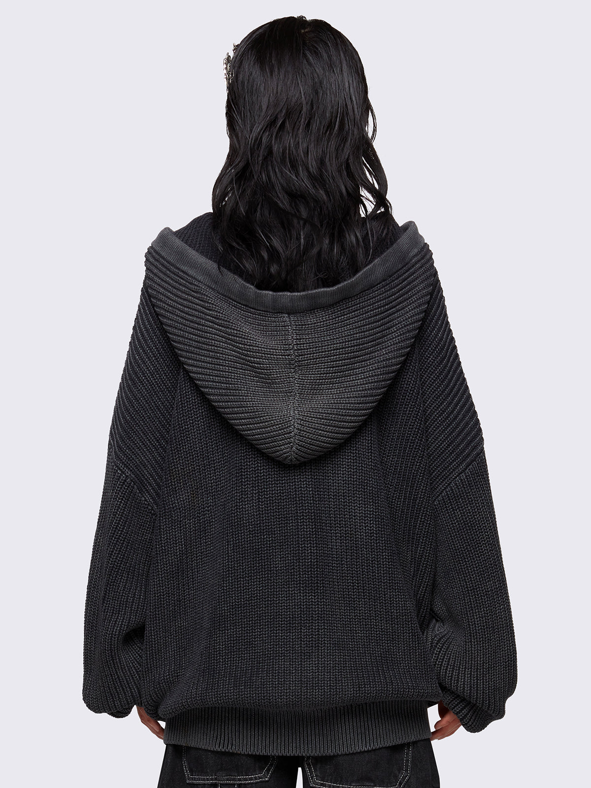 Black washed oversized hoodie cardigan featuring a signature graphic front print. Designed with a chunky ribbed knit, drawstring hood, zip fastening, and kangaroo pockets. The drop shoulders and long sleeves enhance its relaxed, streetwear-inspired fit.