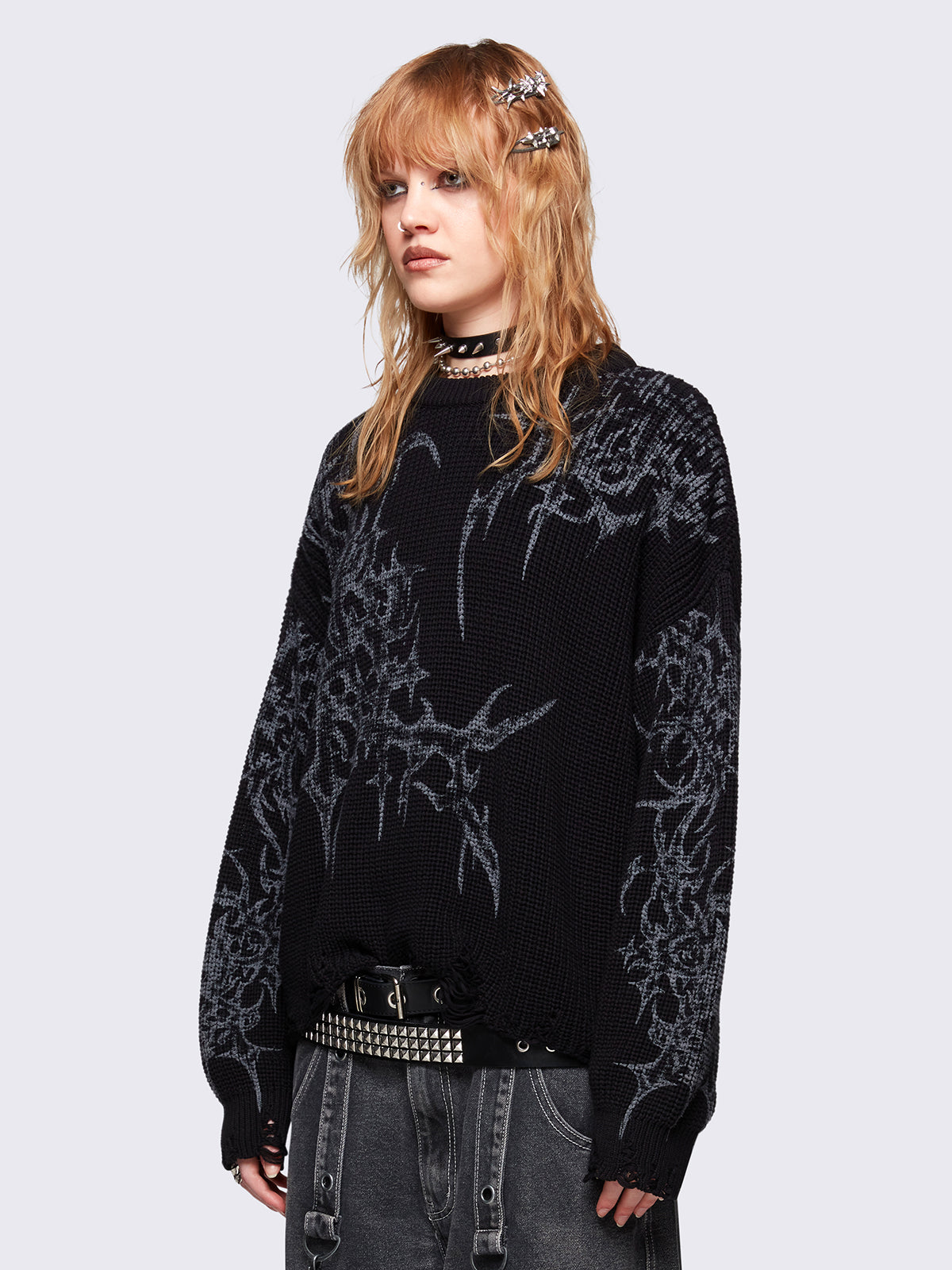 Black knitted sweater with a bold tribal sigilism graphic print. Chunky ribbed knit with distressed details, perfect for grunge and Y2K alt fashion aesthetics.